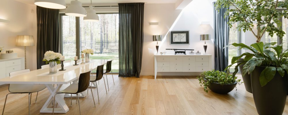 Open and spacious living room with a large window and a dining table